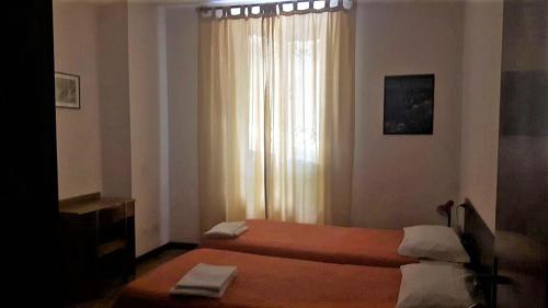 a bedroom with two beds and a window at Miralago Casa in Menaggio
