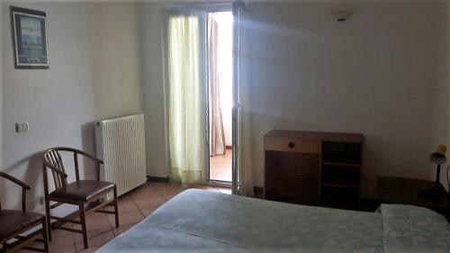 a bedroom with a bed and a chair and a window at Miralago Casa in Menaggio
