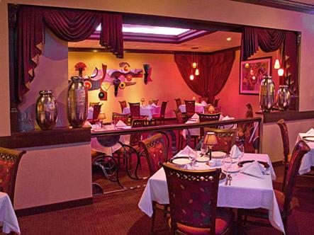 a restaurant with tables and chairs in a room at Salvatores Grand Hotel in Williamsville