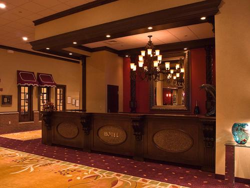 a hotel lobby with a large mirror and a counter at Salvatores Grand Hotel in Williamsville