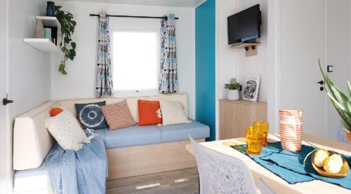 a living room with a blue couch and a table at Camping Country Park Touquin - Site Officiel - Next to Disneyland Paris in Touquin