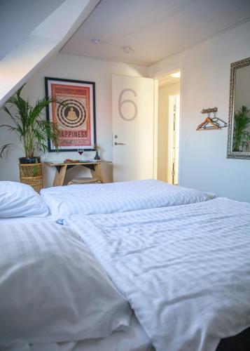 a bedroom with a large white bed in a room at Hotel Sniva in Rønne