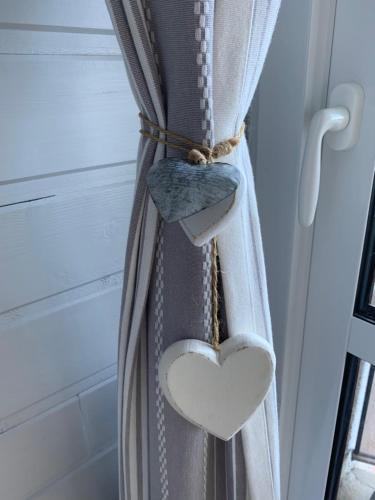 een gordijn met een hart erop dat aan een raam hangt bij Avec balcon, au pied des pistes et randos in Villard-de-Lans