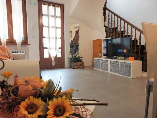 a living room with a television and a table with flowers at Casa Edda in Malcesine