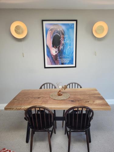 a wooden table with chairs and a picture on the wall at Aiteall Bed and Breakfast in Liscannor