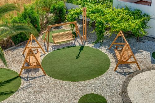 a circle of grass with a bench and a swing at Hotel Benois in Galissas