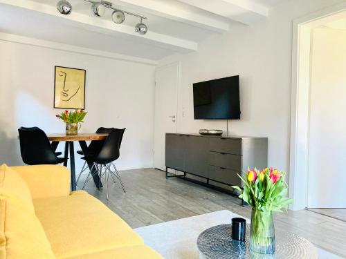 a living room with a couch and a table with a television at Die Stader Gästewohnung in Stade