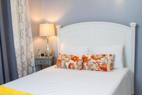 a white bed with a pillow and a lamp on a table at Villas Richmond Estate - Ocho Rios in Richmond