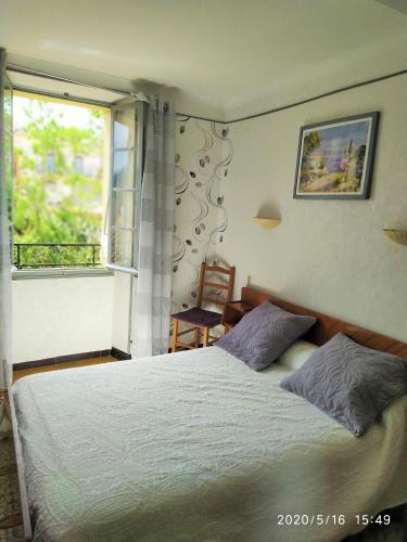 een slaapkamer met een groot bed en een raam bij Appartement 1er étage banyuls sur mer départs et arrivées les samedis in Banyuls-sur-Mer