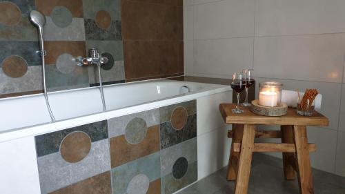 a bathroom with a tub and a table with a candle at Ferienidyll Hofmann in Glowe