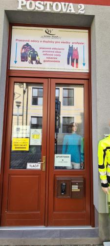 una puerta a un restaurante con señales en él en Centrum Apartman LEYLA, en Bardejov