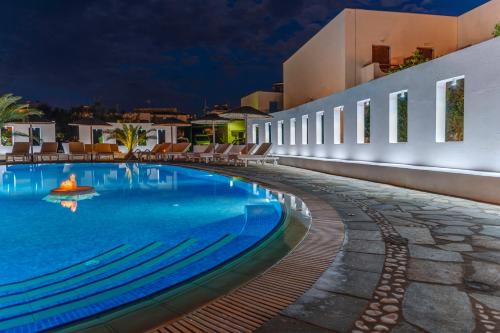 a swimming pool in front of a building at night at Hotel Benois in Galissas