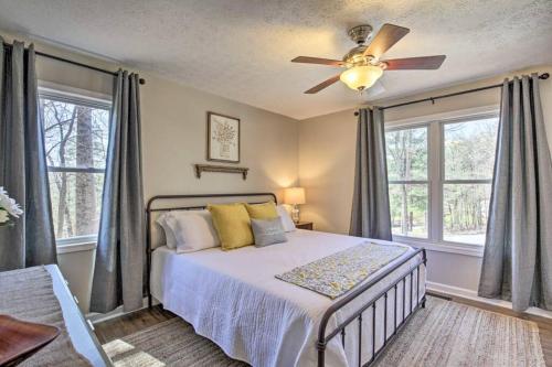 a bedroom with a bed with a ceiling fan and windows at Less than 3 miles to Downtown with firepit in Ellijay