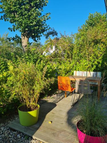 a wooden deck with a table and chairs and plants at Ferienidyll Hofmann in Glowe