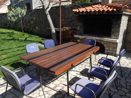 a wooden table and chairs in front of a fireplace at Apartman Megy in Senj
