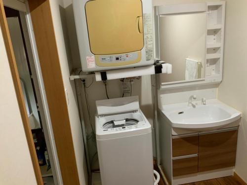 a small bathroom with a sink and a microwave at AZ Hotel in Amami - Villa with private outdoor Jacuzzi in Amami