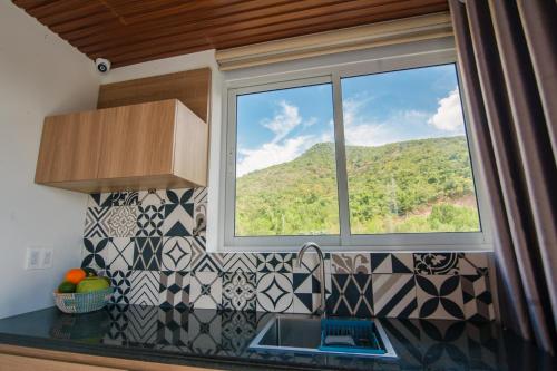 a kitchen with a window and a sink and a mountain at The View Hotel in Cam Lâm