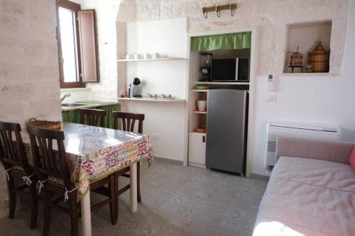 a kitchen with a table and chairs and a refrigerator at Pietra d'angolo in Locorotondo