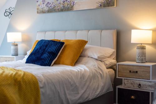 a bedroom with a white bed with two lamps at Hope Street in Filey