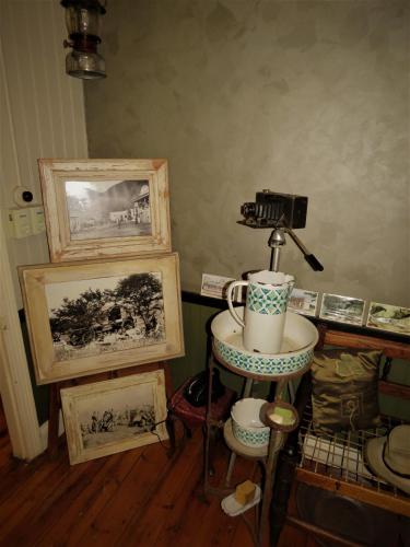 a room with paintings and a table with a cup on it at Fountain Baths Guest Cottages in Barberton