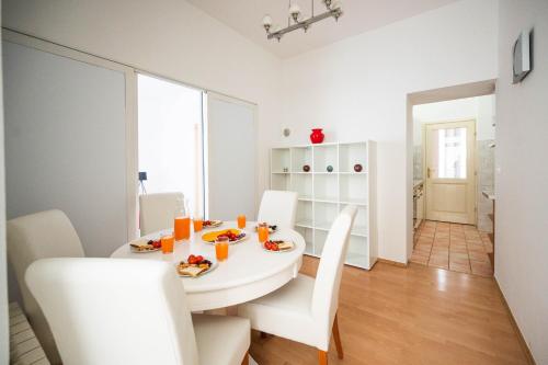 a white dining room with a white table and chairs at Bright and Modern 1BDR Apartment in the Center in Sarajevo