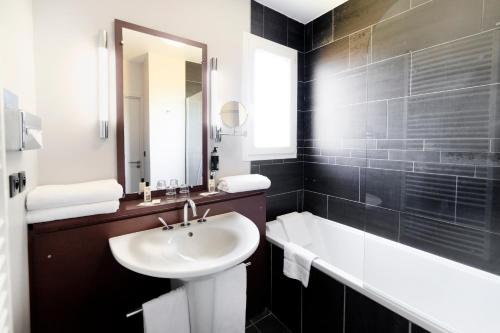 佩里納特·萊斯·薩爾列夫的住宿－吉爾格維貝斯特維斯特優質酒店，黑白浴室设有水槽和浴缸。