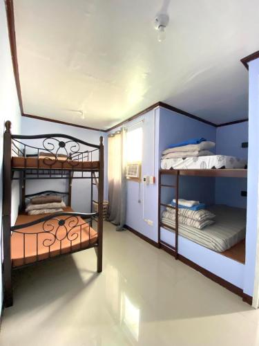 a room with two bunk beds in a room at Haus of Emerald - Astana by Ollie in Mactan