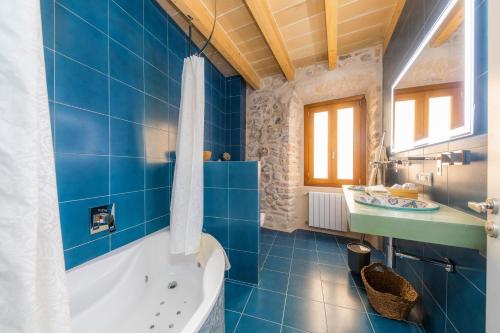 a blue bathroom with a tub and a sink at Casa Abeurador in Artá