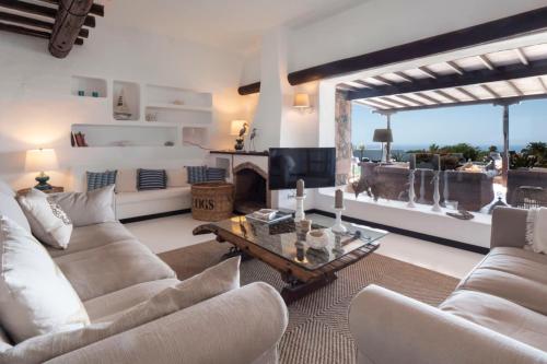 uma sala de estar com mobiliário branco e uma lareira em Finca Paraíso - Finest Villa with incredible views over Puerto del Carmen em Puerto del Carmen