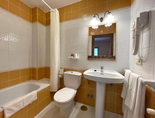 een badkamer met een toilet, een wastafel en een bad bij Santu Colás in Corao
