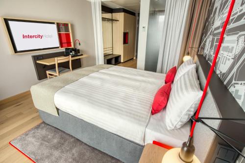 a bedroom with a bed and a flat screen tv at IntercityHotel Amsterdam Airport in Hoofddorp