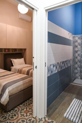 a bedroom with two beds and a shower at Xenia Home in Reggio Calabria
