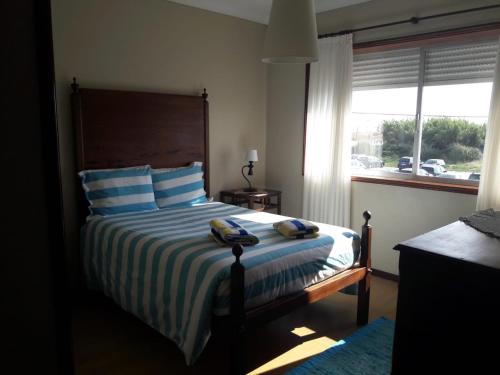 a bedroom with a bed with two towels on it at Oporto Beach House in Arcozelo