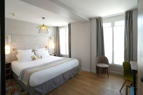 a hotel room with a large bed and windows at Hotel Litteraire Marcel Ayme, BW Premier Collection in Paris