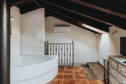 a bathroom with a large white tub in a room at Posada del tiempo in Villavieja del Lozoya