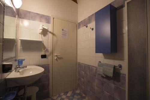 a small bathroom with a sink and a door at Hotel Desiree in Cesenatico