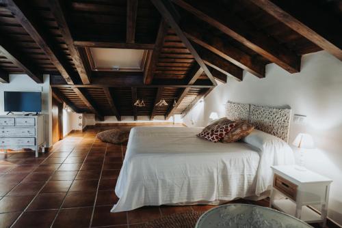 a bedroom with a large bed and wooden ceilings at Posada del tiempo in Villavieja del Lozoya