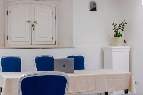 a table with blue chairs and a laptop on it at Esedra Hotel in Rimini