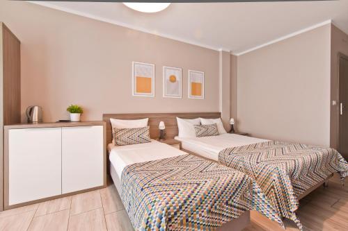a bedroom with two beds and a cabinet at Kamienica Mielno in Mielno