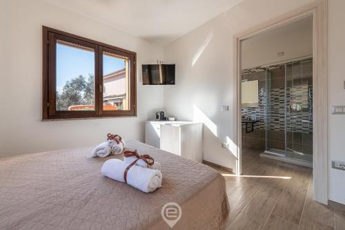 1 dormitorio con 1 cama grande y toallas. en Villa Monica Suites - Wonderful Sardinia, en Iglesias