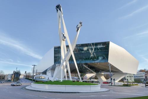 a building with a statue in the middle of a street at ibis Styles Stuttgart Vaihingen in Stuttgart