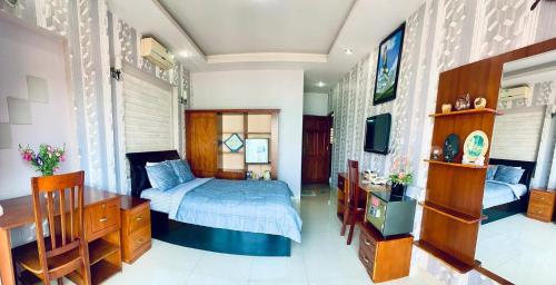 a bedroom with a bed and a desk and a tv at Lucys Hotel in Vung Tau
