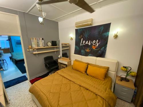 Schlafzimmer mit einem Bett mit gelber Bettwäsche und einem Schreibtisch in der Unterkunft MARIDA HOMESTAY MusIim Only in Seremban