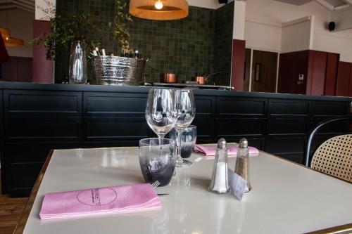 a table with wine glasses and napkins on it at Best Western Porte du Forez in Andrézieux-Bouthéon