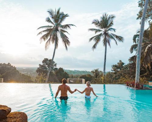 a man and woman are holding hands in a swimming pool at Tabula Rasa Resort & Spa in Galle