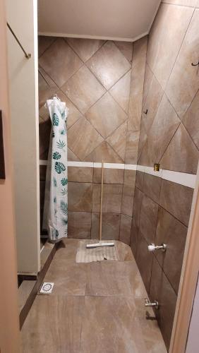 a bathroom with a shower with a tiled floor at Astrolabio Hostel in San Carlos de Bariloche