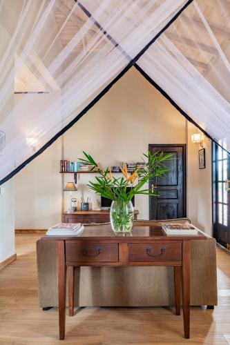 a room with a table with a vase of flowers on it at Tabula Rasa Resort & Spa in Galle