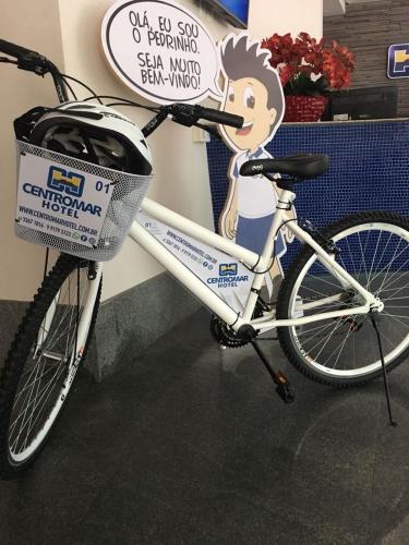 a bike with a basket parked next to a sign at Centromar Hotel in Balneário Camboriú