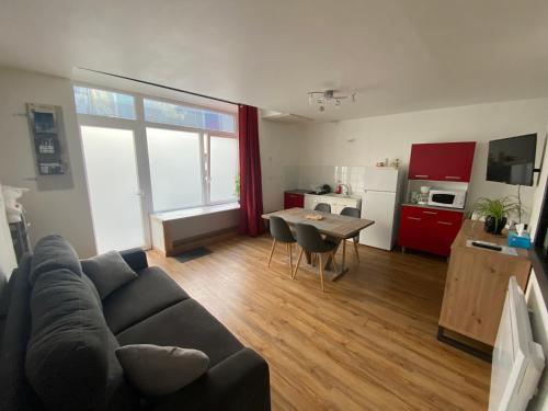 un salon avec un canapé et une table et une cuisine dans l'établissement Joli T2 dans une maison de village, à Châteauroux-les-Alpes