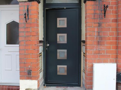 a black door on a brick building with a white door at Townhouse PLUS @ 282 Walthall Street in Crewe